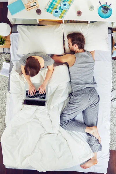 Mujer usando portátil en la cama — Foto de Stock