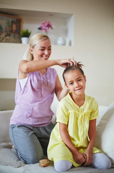 Mãe fazendo penteado para filha — Fotografia de Stock