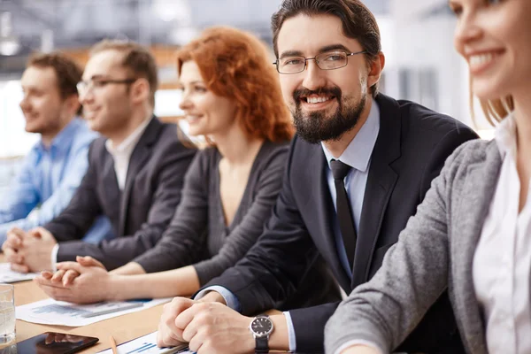 Affärsman sitter bland medarbetare vid konferens — Stockfoto