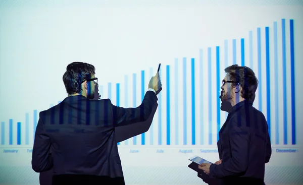 Businessman with touchpad listening to his colleague — Stock Photo, Image