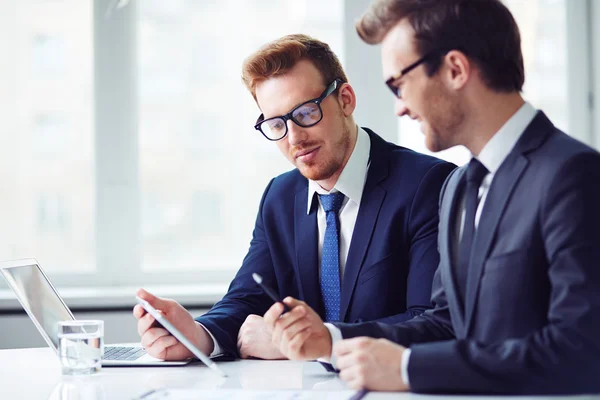 Hombres de negocios que aprenden datos en touchpad — Foto de Stock