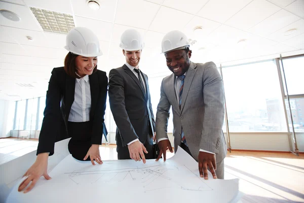 Confident architects looking at blueprint — Stock Photo, Image