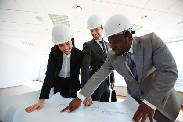 Arquitectos confiados mirando el plano — Foto de Stock