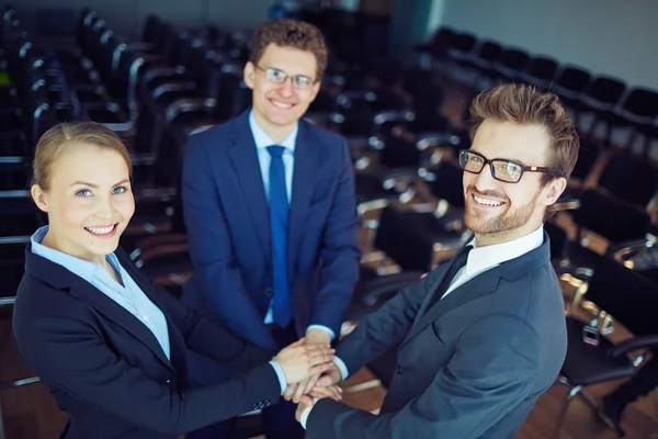 Happy colleagues making pile of hands — Stock Photo, Image