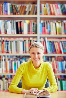 Kitaplığı'nda oturan kadın