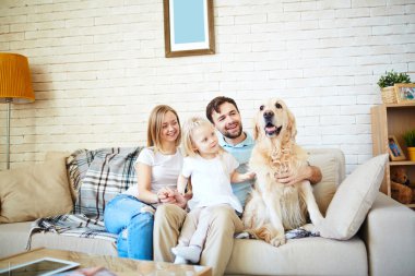 Aile ile kanepede oturan köpek