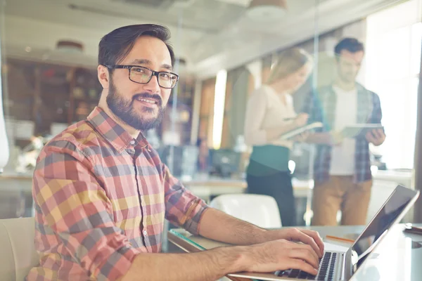 Büroangestellte tippt auf Laptop — Stockfoto