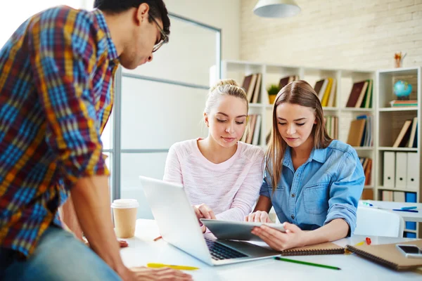 Chicas mirando a través de datos en touchpad — Foto de Stock