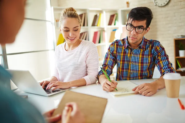 Amigos haciendo tarea en casa en la biblioteca — Foto de Stock