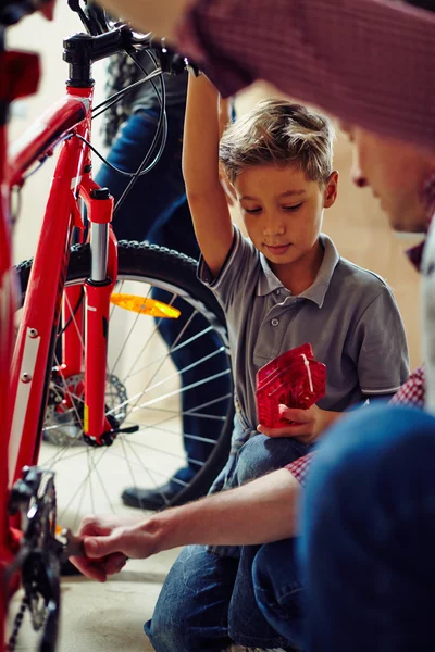 Vater zeigt Sohn, wie man Fahrrad repariert — Stockfoto