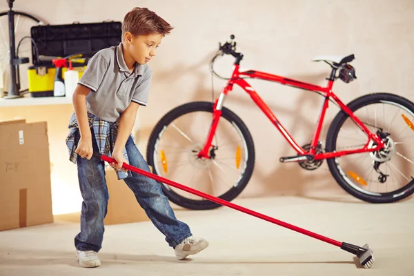 Little boy doing cleanup in garage — Stock Photo, Image