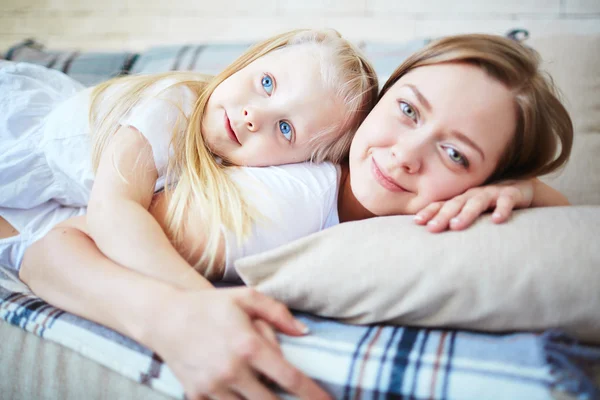 Meisje en haar moeder ontspannen op de sofa — Stockfoto