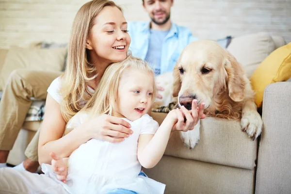 Mère et fille nourrissant leur chien — Photo