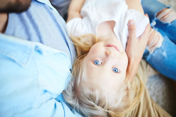 Meisje op haar vaders wapens — Stockfoto