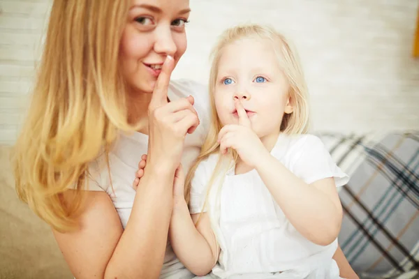 Menina e mãe mostrando shh gesto — Fotografia de Stock