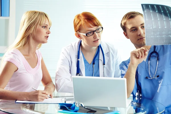 Médico comentando raio-X para seus colegas — Fotografia de Stock