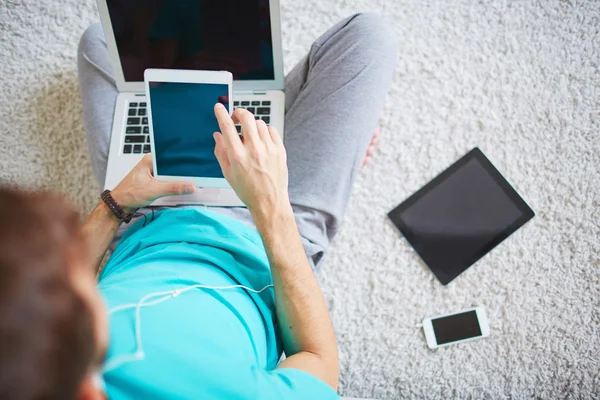 Homem sentado no chão e usando gadgets — Fotografia de Stock