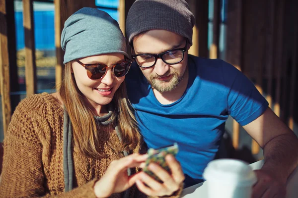 Пара со смартфоном в кафе — стоковое фото