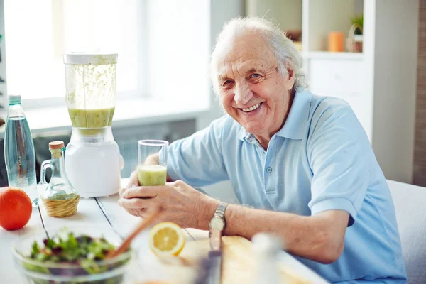 Senior man met glas smoothie — Stockfoto