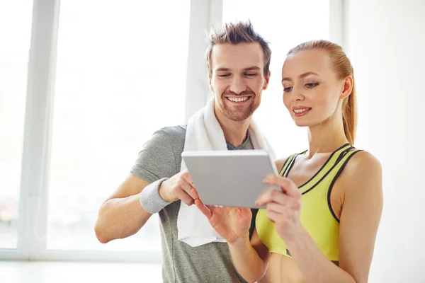 Sporty couple using touchpad — Stock Photo, Image