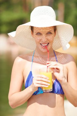 Portakal suyu içme şapkalı kadın