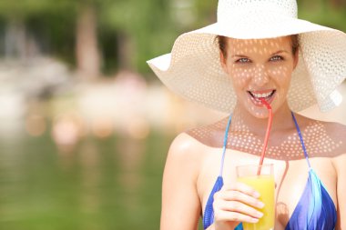 Portakal suyu içme şapkalı kadın