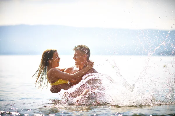 Homme tenant femme dans l'eau — Photo