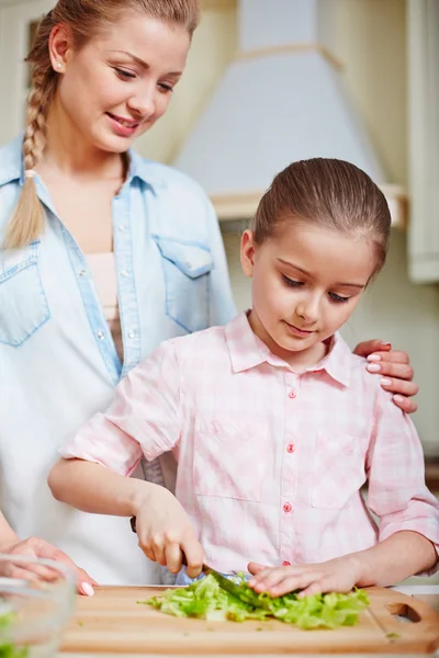 Mulher e filha cozinhar salada — Fotografia de Stock