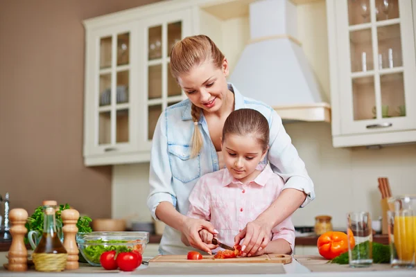 Kvinna och dotter skära tomater — Stockfoto