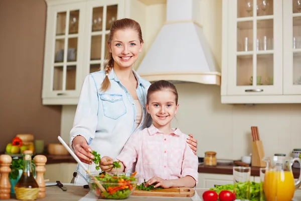 Mother and girl with bowl of vegetable salad — Stock Photo, Image