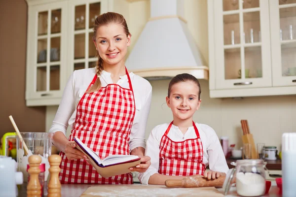 Tjej och mamma med kokbok — Stockfoto