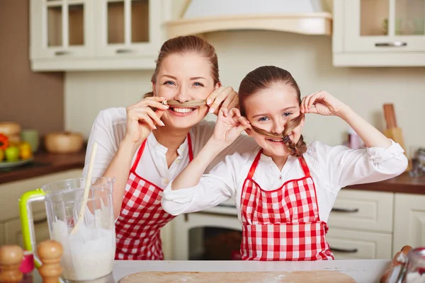 Girl and mother making moustaches of their hair — Stock Photo, Image