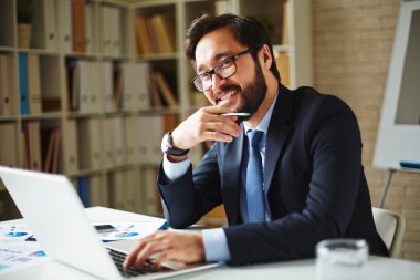dizüstü bilgisayar kullanarak gözlük işadamı