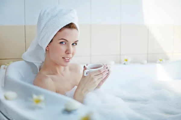 Mujer sentada en la bañera con taza de té —  Fotos de Stock