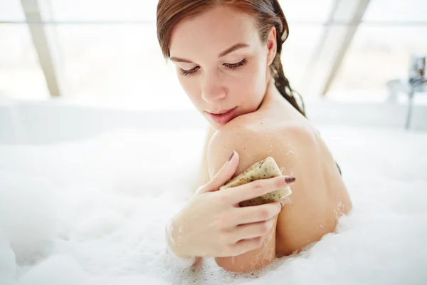 Kvinnan skrubba hennes axel med soap bar — Stockfoto