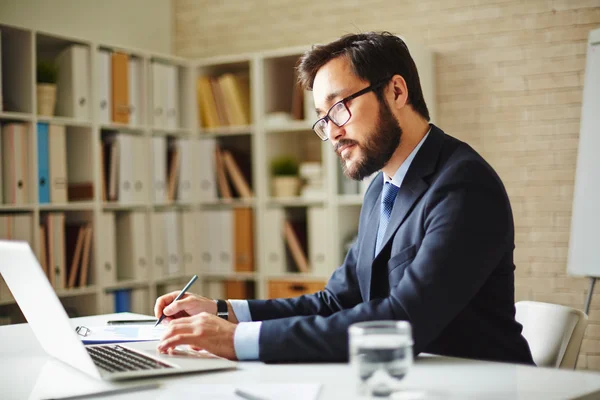 Uomo d'affari che utilizza laptop in ufficio — Foto Stock