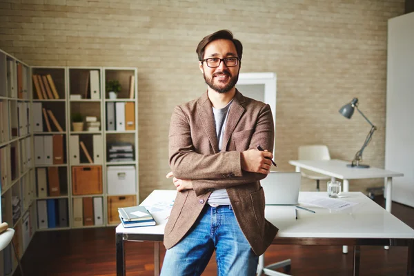 Zakenman die permanent in de buurt van tabel in office — Stockfoto