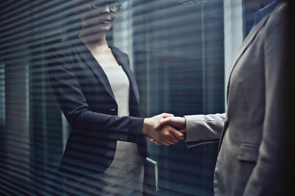 在黑暗的办公室女企业家握手 — 图库照片