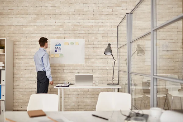 Businessman standing by workplace — Stock Photo, Image