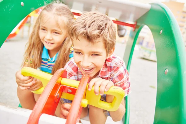 Ragazza amichevole e ragazzo sul parco giochi — Foto Stock