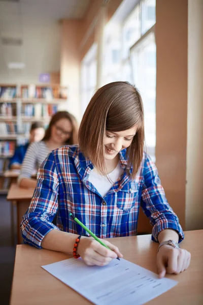 Girl filling in gaps in test form — Stock Photo, Image