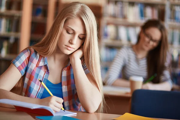 Girl making notes at lesson — Stock Photo, Image