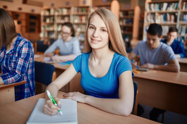 teenage girl sitting by desk