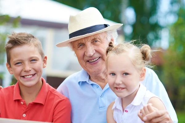Старший мужчина с двумя внуками — стоковое фото