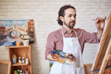 Ressam tuvalde resim yapıyor