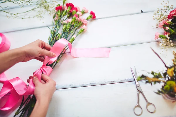 Handen koppelverkoop boeket met roze lint — Stockfoto