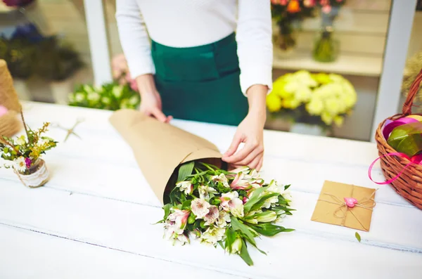 Fiorista avvolgendo bouquet — Foto Stock