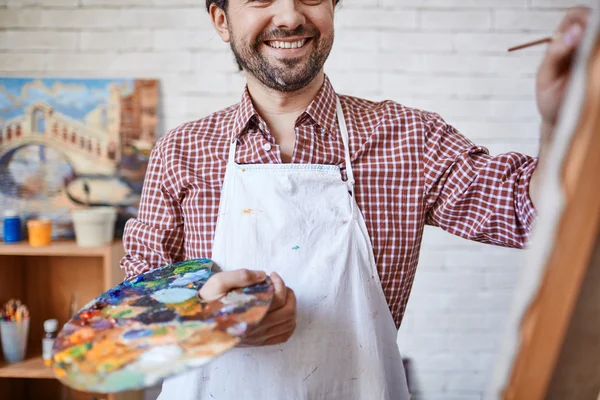Artist holding palette and  painting — Stock Photo, Image