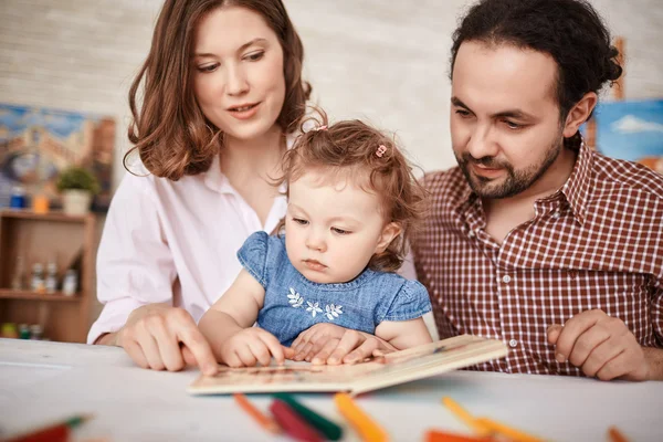 Rodiče a malou dcerou, společné čtení — Stock fotografie