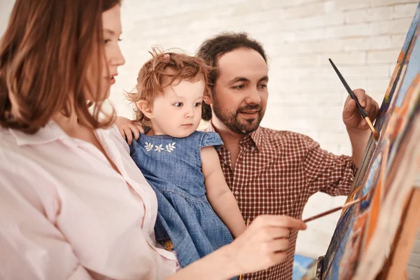 Casal mostrando filha como pintar — Fotografia de Stock